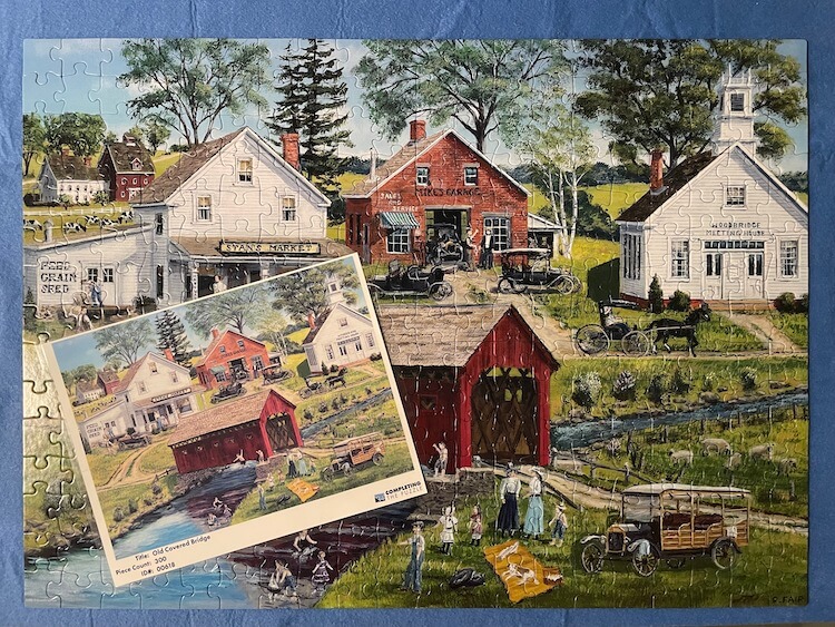 jigsaw puzzle strategy: A completed puzzle of two white buildings and a red building with a red covered bridge