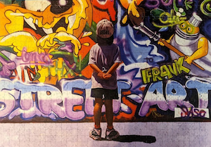 Boy staring at a wall of graffiti