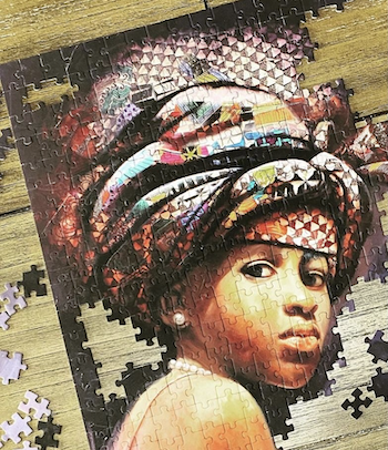 Puzzle in progress of a girl with a head scarf looking at the camera
