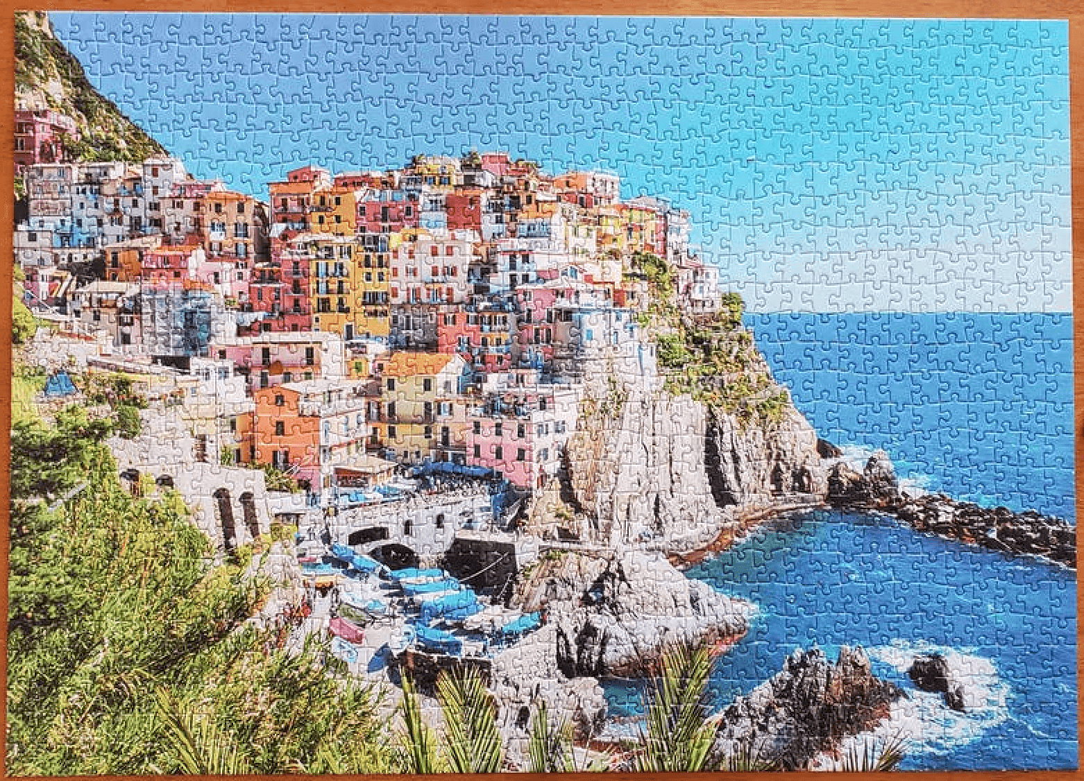 Colorful buildings on a cliff by the ocean with a blue sky