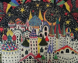 Puzzle image of white buildings with colorful, whimsical roofs on a black background with stars and flags