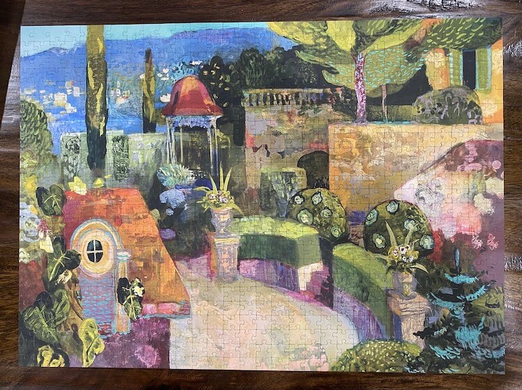 Puzzle of a painting of a village in Italy with mountains and a lake in the background