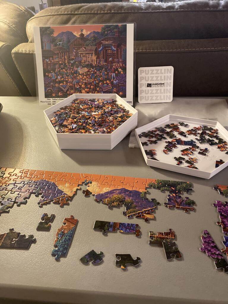 A partially done puzzle with the pieces in sorter trays.